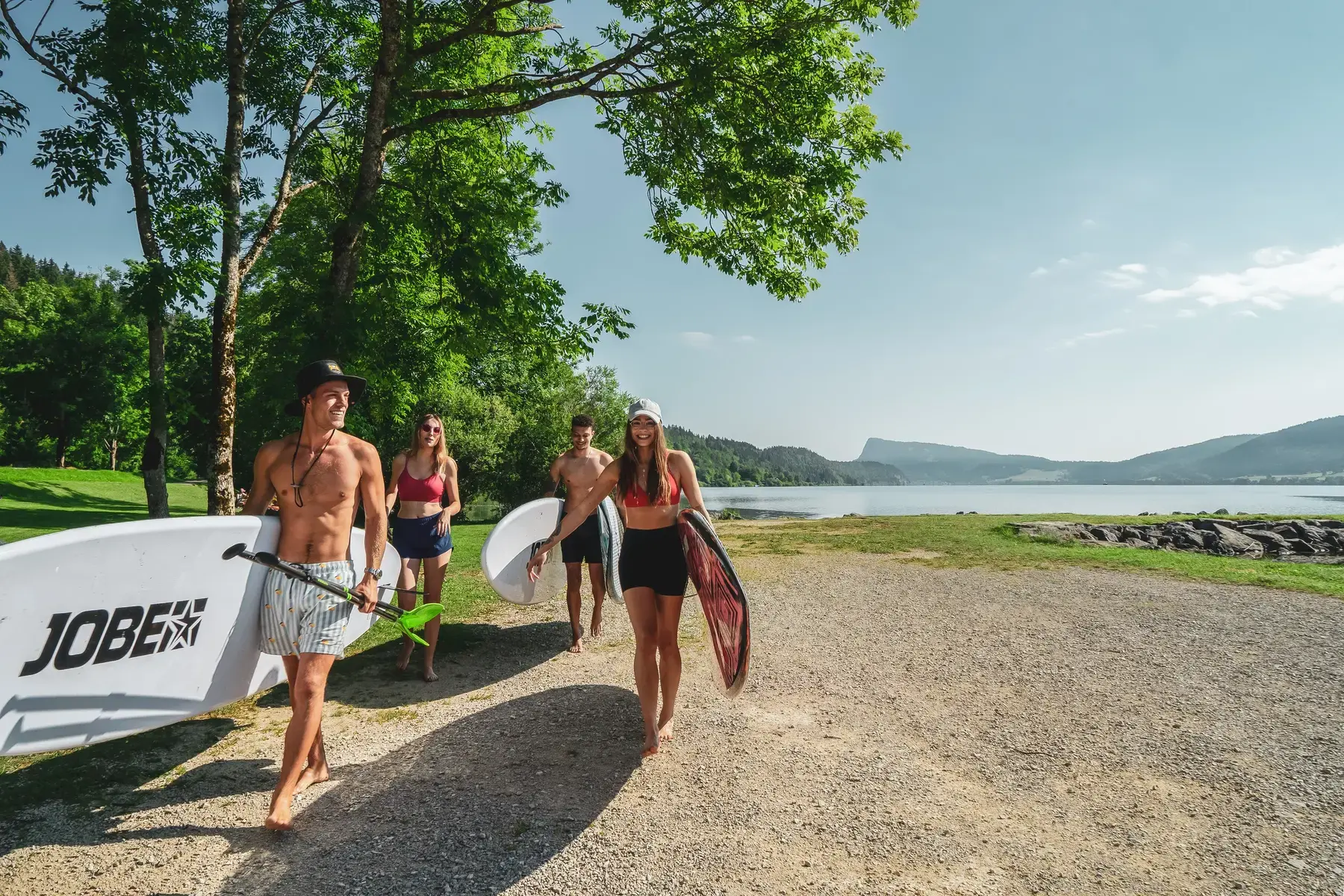 Groupe portant ses paddles au bord du Lac de Joux, prêt à embarquer.